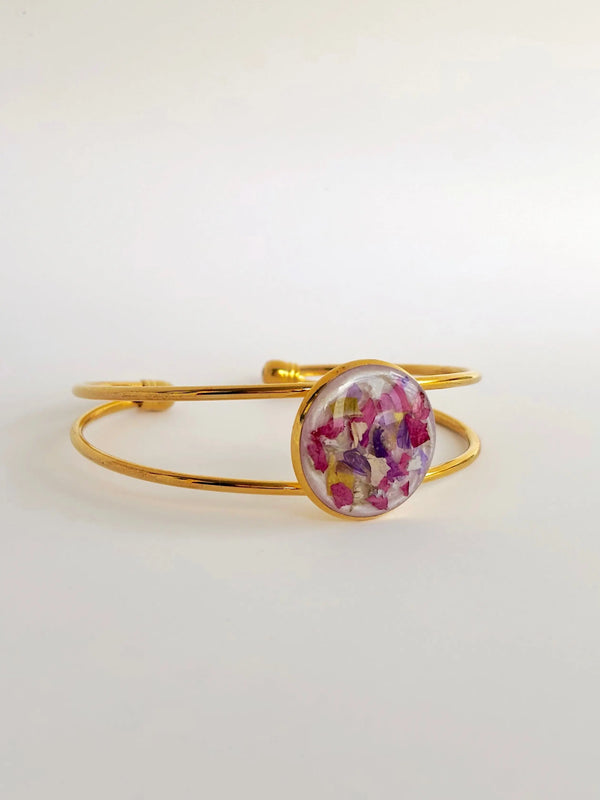 Amara Cuff featuring colorful dried flowers encapsulated in flower preservation resin, gold finish.