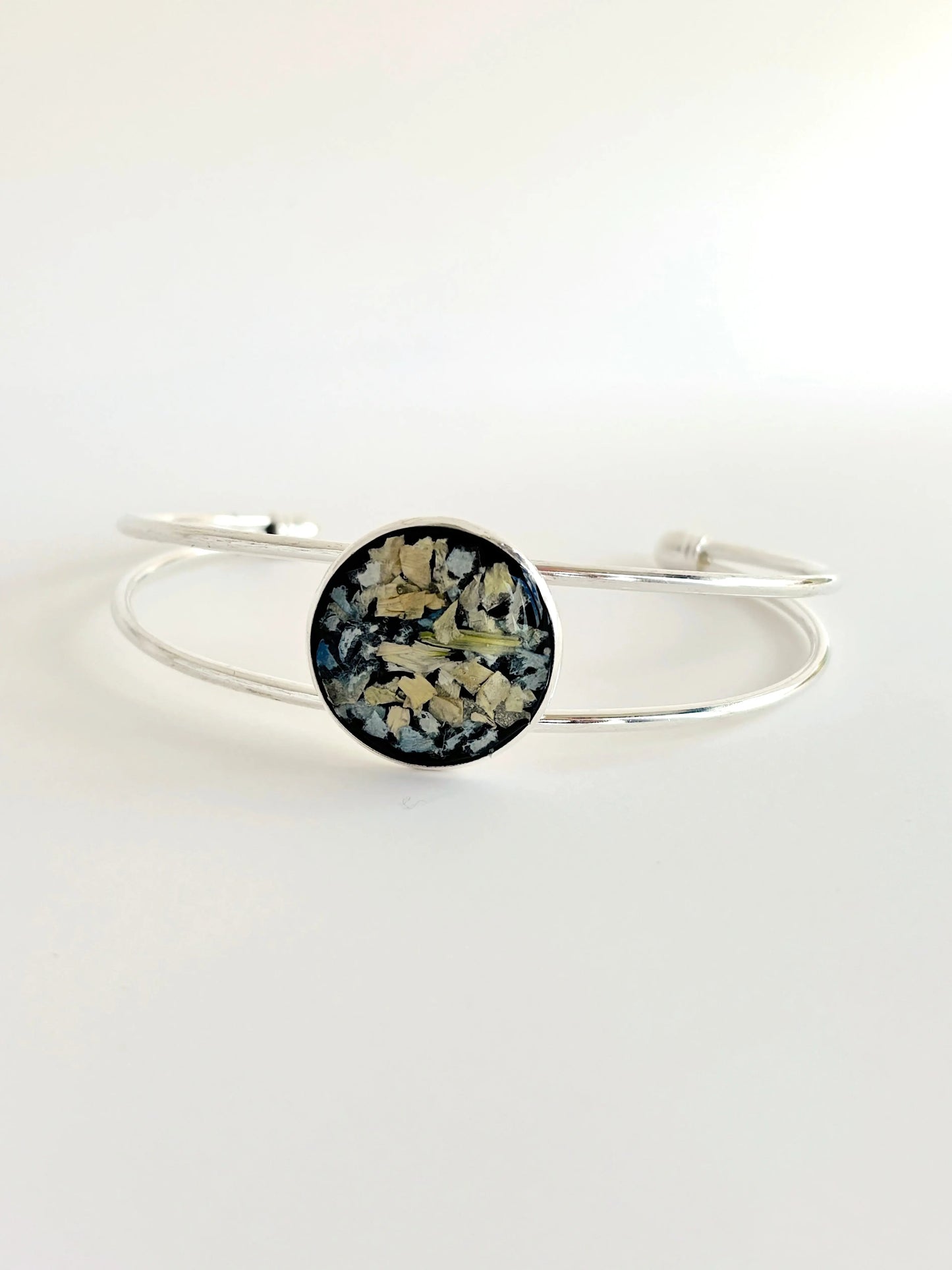 Amara Cuff made with preserved flowers in a striking silver setting, highlighting flower preservation resin.