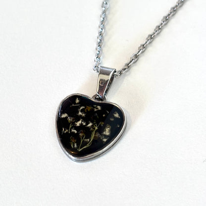 Bloomsake silver heart pendant necklace with preserved flowers in dark resin, full necklace hanging view.