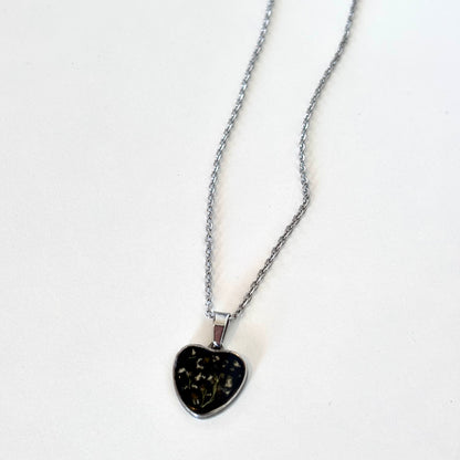 Close-up detail of Bloomsake silver heart pendant necklace showing preserved flowers in dark resin.